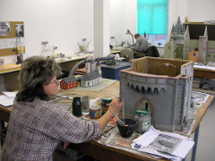 Eine Mitarbeiterin der Modellbauwerkstatt arbeitet an einem Modell des Eschenheimer Turms, der in von Frankfurt am Main steht. Foto: VIA REGIA Begegnungsraum - Landesverband Sachsen e.V.