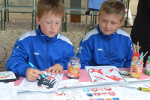 Am VIA REGIA Infostand malen zwei Jungs Stadtwappen mit Wasserfarben aus